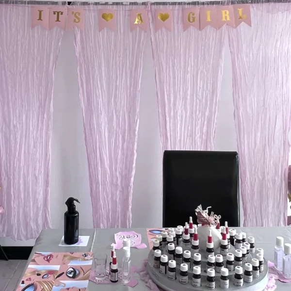 De feestelijk gedecoreerde tafel bij de achtergrondwand voor de mama to be tijdens een babyshower in Roosendaal. Roze